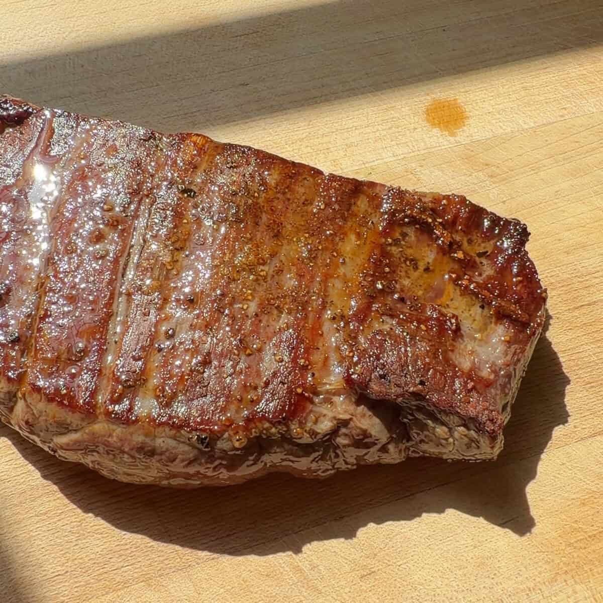 Seared steak on cutting board.