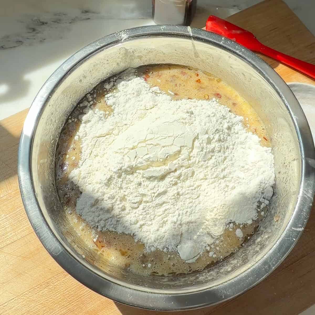 Butter Pecan Banana Bread batter with dry ingredients on top.