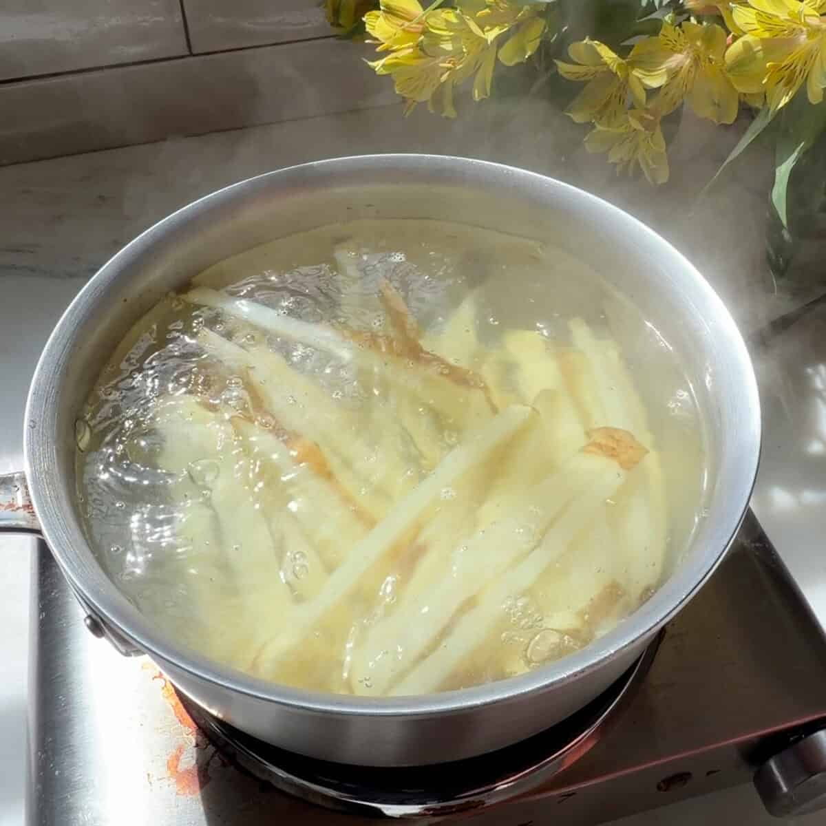 French fry cut potatoes in boiling water.
