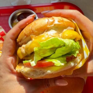 Hands holding In-N-Out Burger.