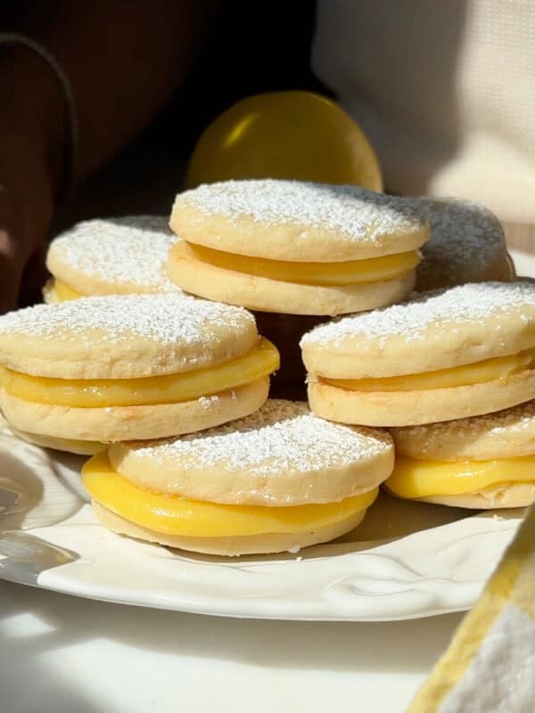Lemon Alfajores stacked on a plate.