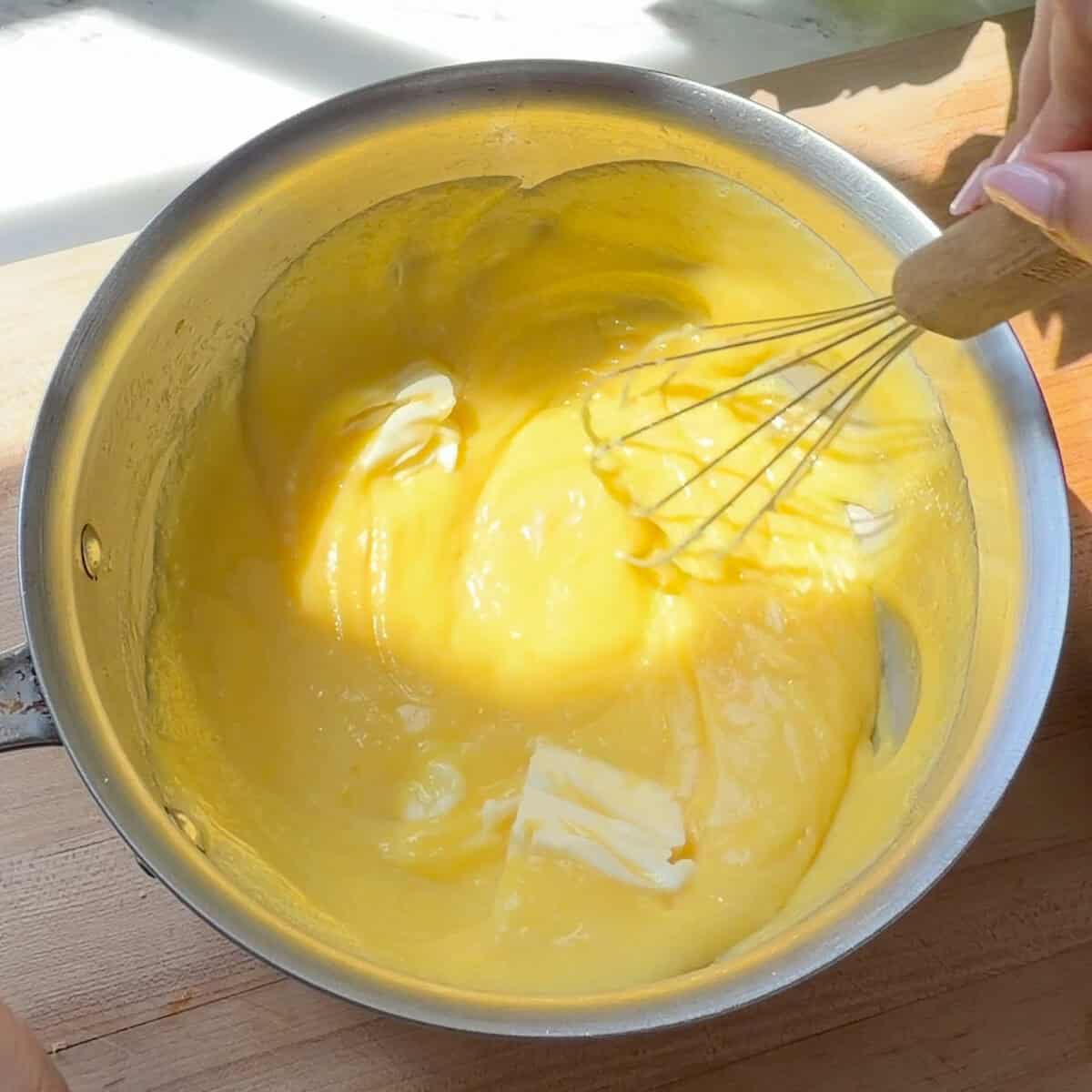 Whisking butter into lemon curd.