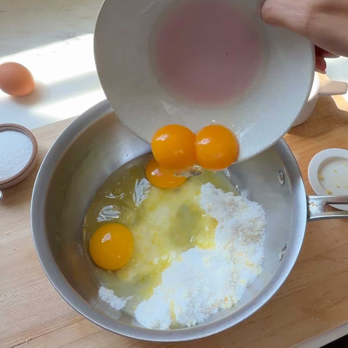 Adding eggs to pot.