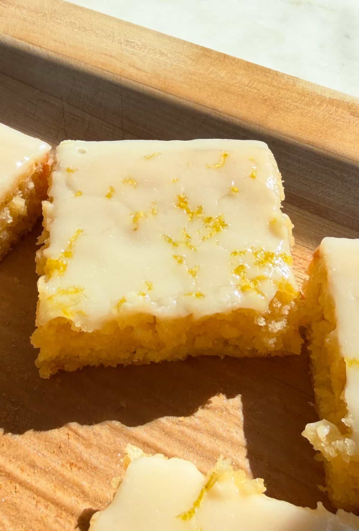 Slices of lemon brownies on cutting board.