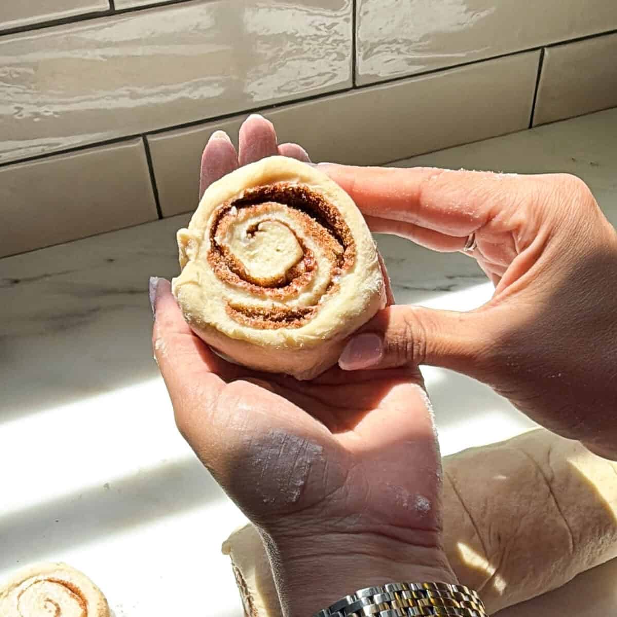 Banana Bread Cinnamon Roll unbaked in hands.