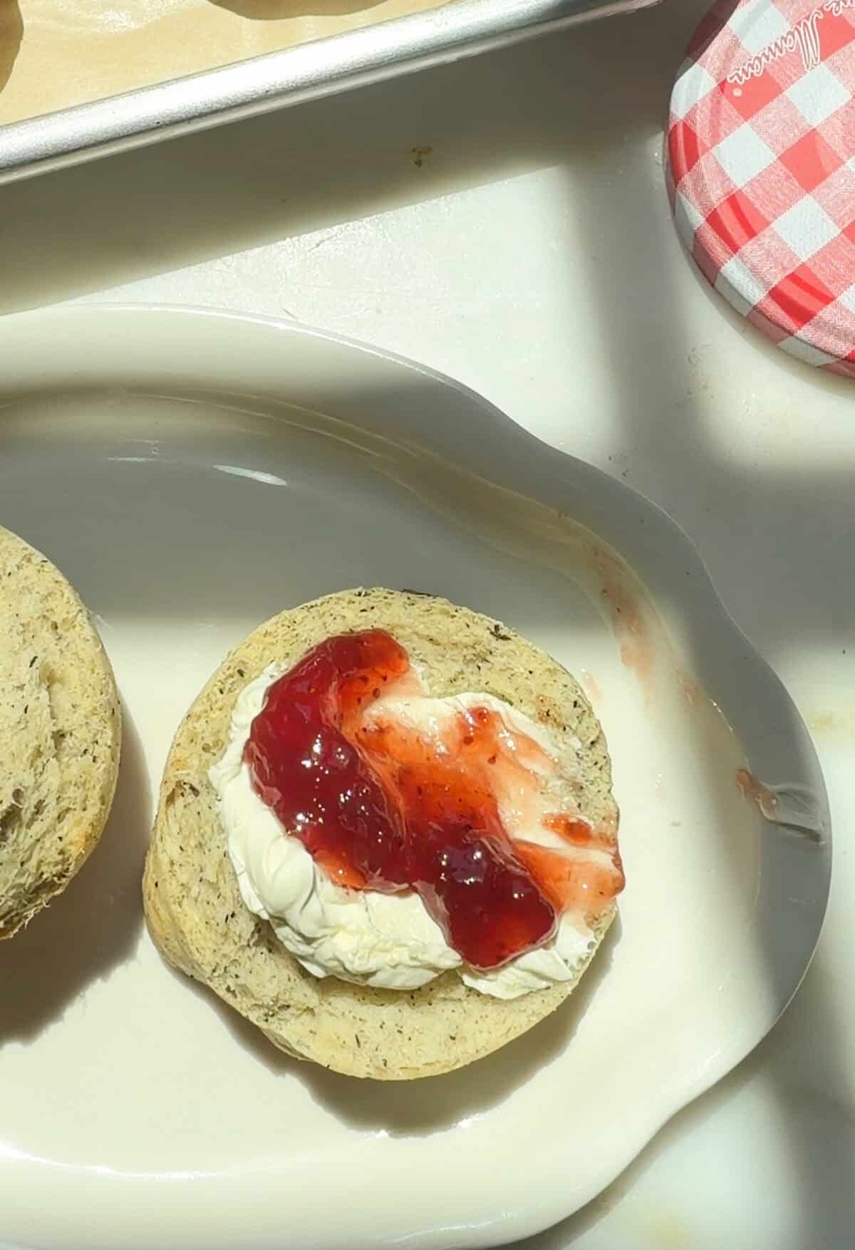 क्लॉटेड क्रीम और स्ट्रॉबेरी जैम के साथ अर्ल ग्रे स्वाद वाला ब्रिटिश स्कोन।