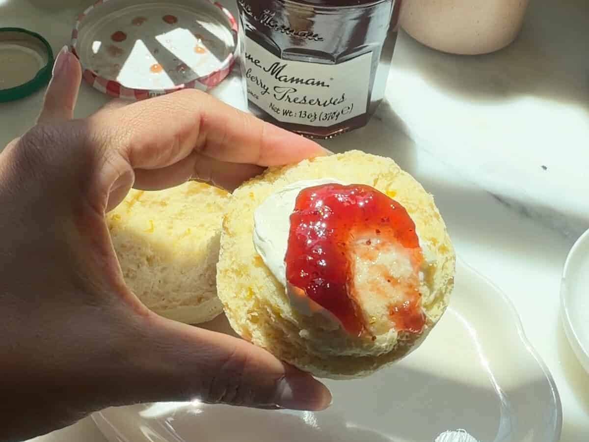 Orange flavored British Scone with clotted cream and strawberry jam.