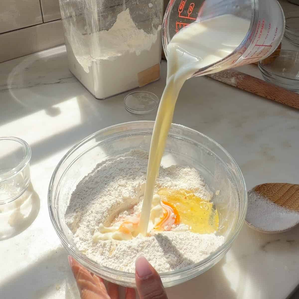 Adding milk and egg to flour mixture.
