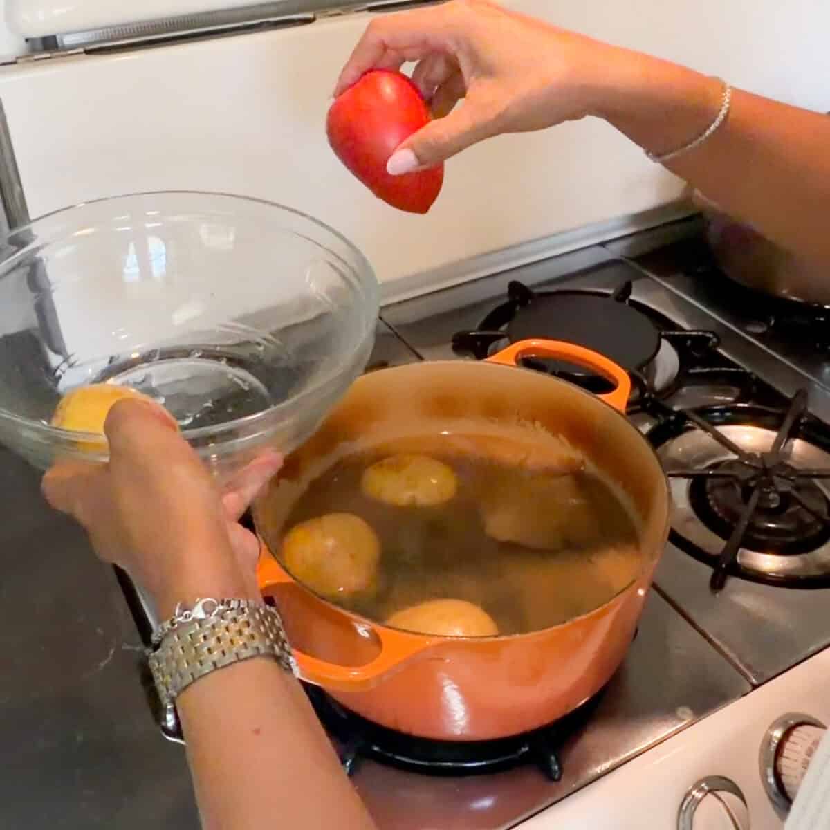 Adding tomato and potatoes to braised beef.