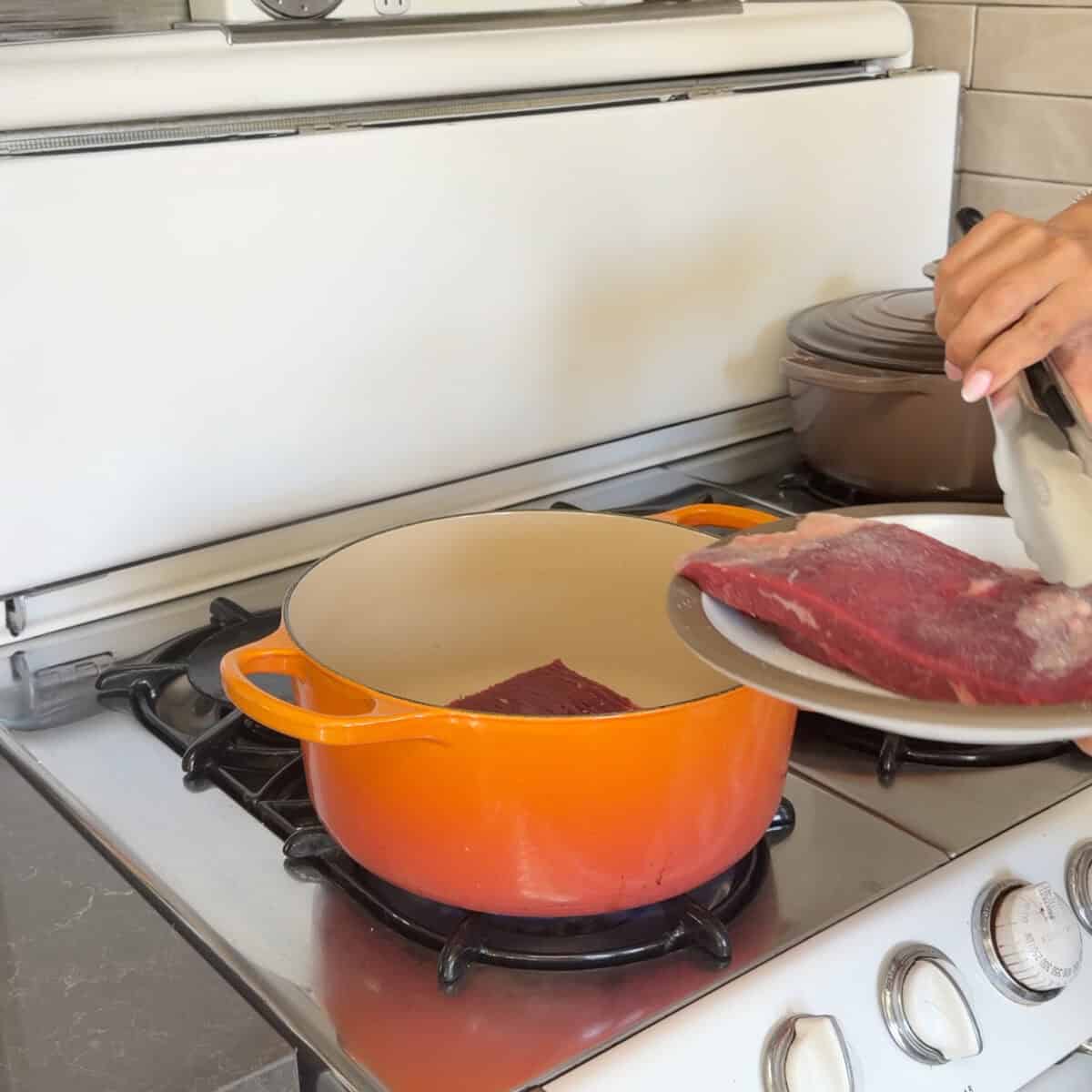 Searing flank steak in Dutch oven on the stove.