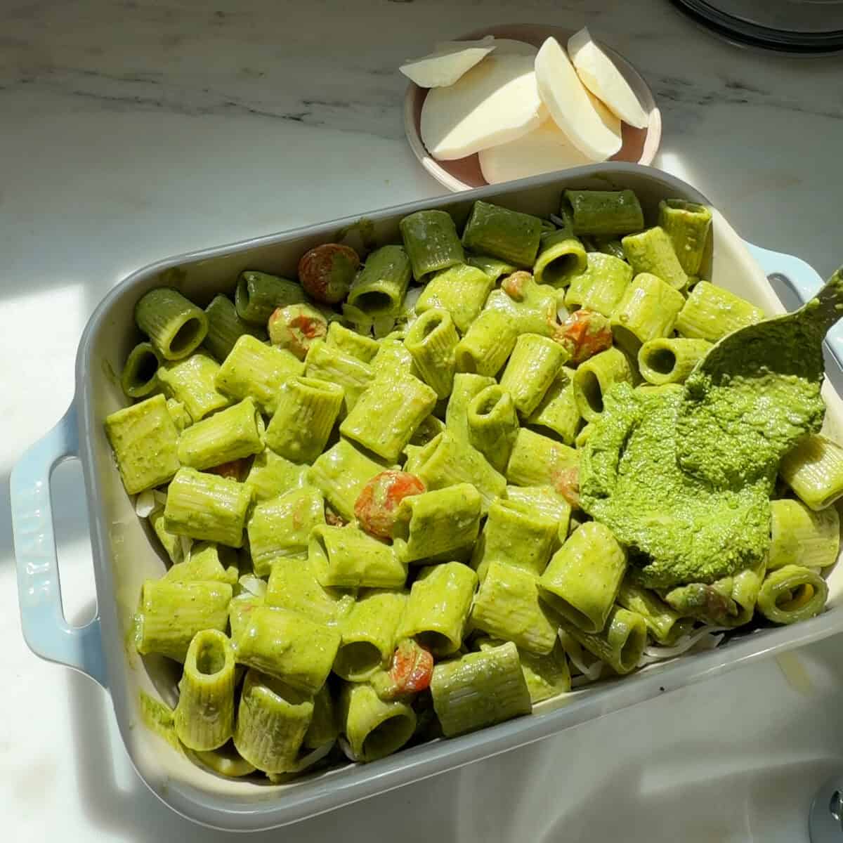 पास्ता के ऊपर चम्मच से आरक्षित पेस्टो डालें।