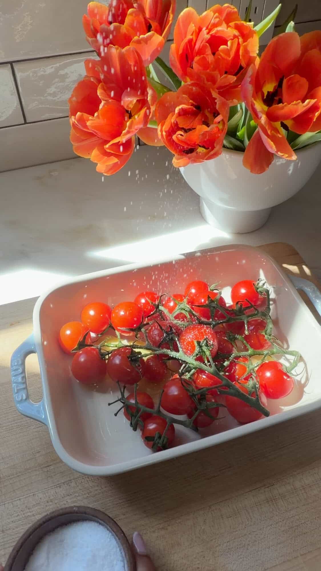 बेकिंग डिश में नमक और जैतून के तेल के साथ चेरी टमाटर।