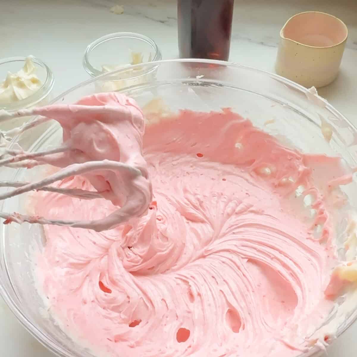 Mixing strawberry cream cheese frosting.