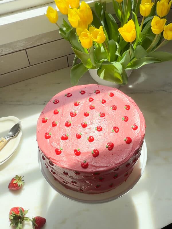 Whole strawberry layer cake on cake stand.