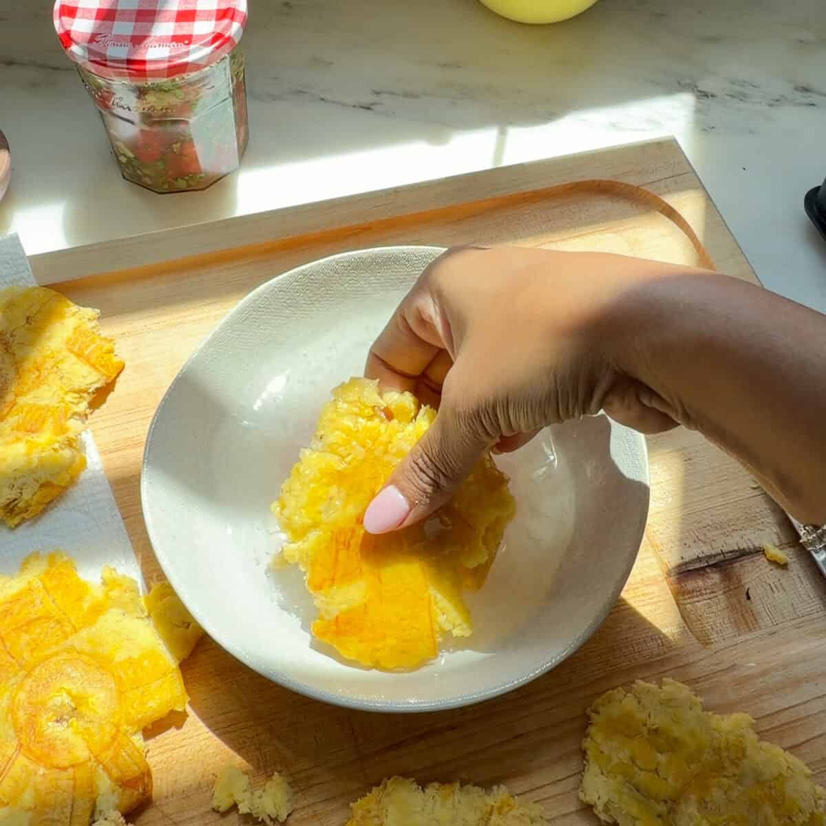 Dipping plantain discs in garlic water.