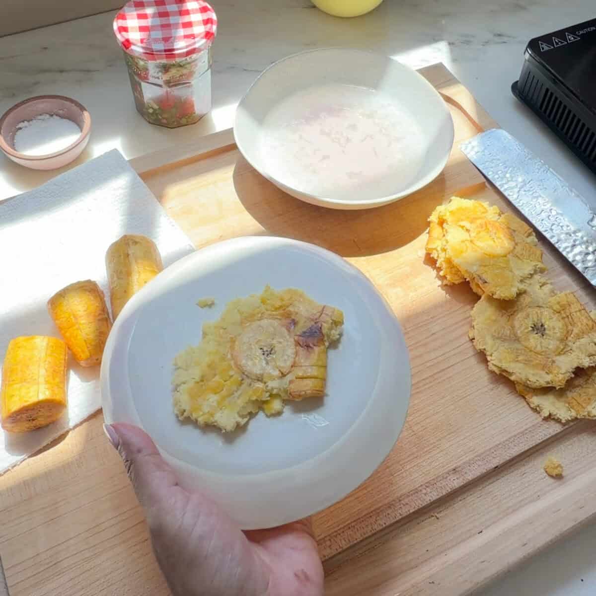 Plantain smashed into disc on the bottom of a plate.