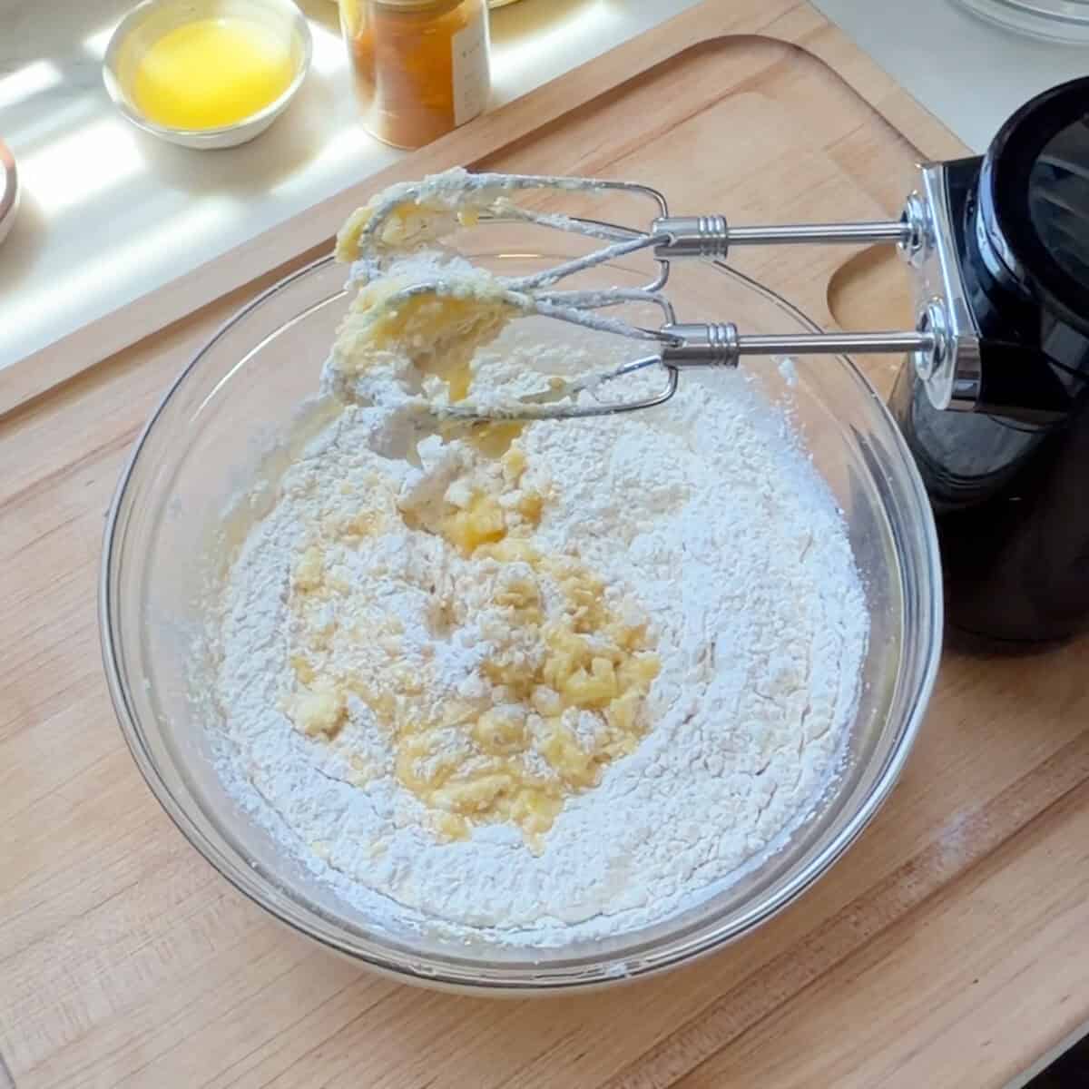 Dry ingredients added to wet ingredients in a bowl.