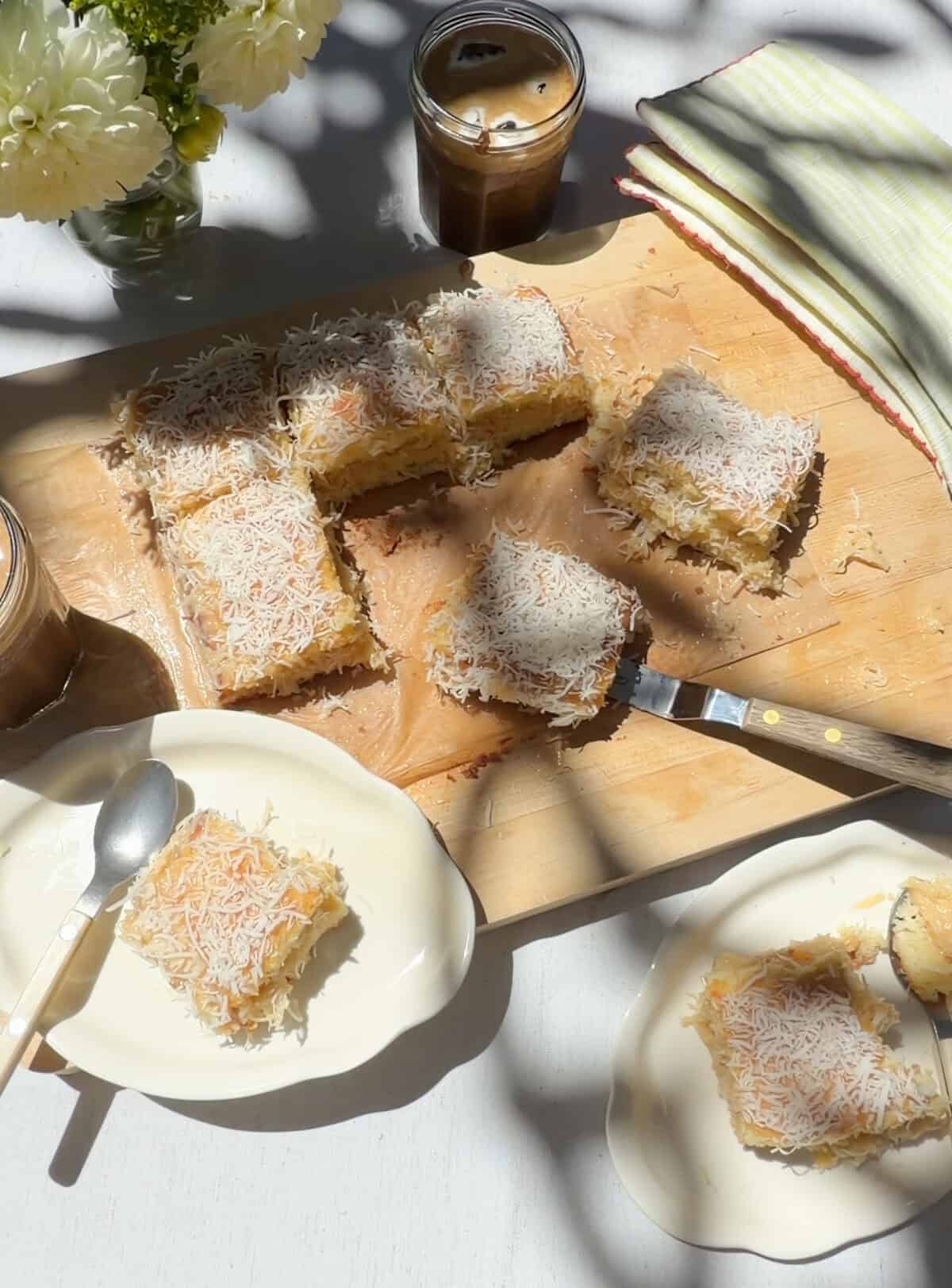 Slices of cake on plates and cutting board with glasses of iced coffee.
