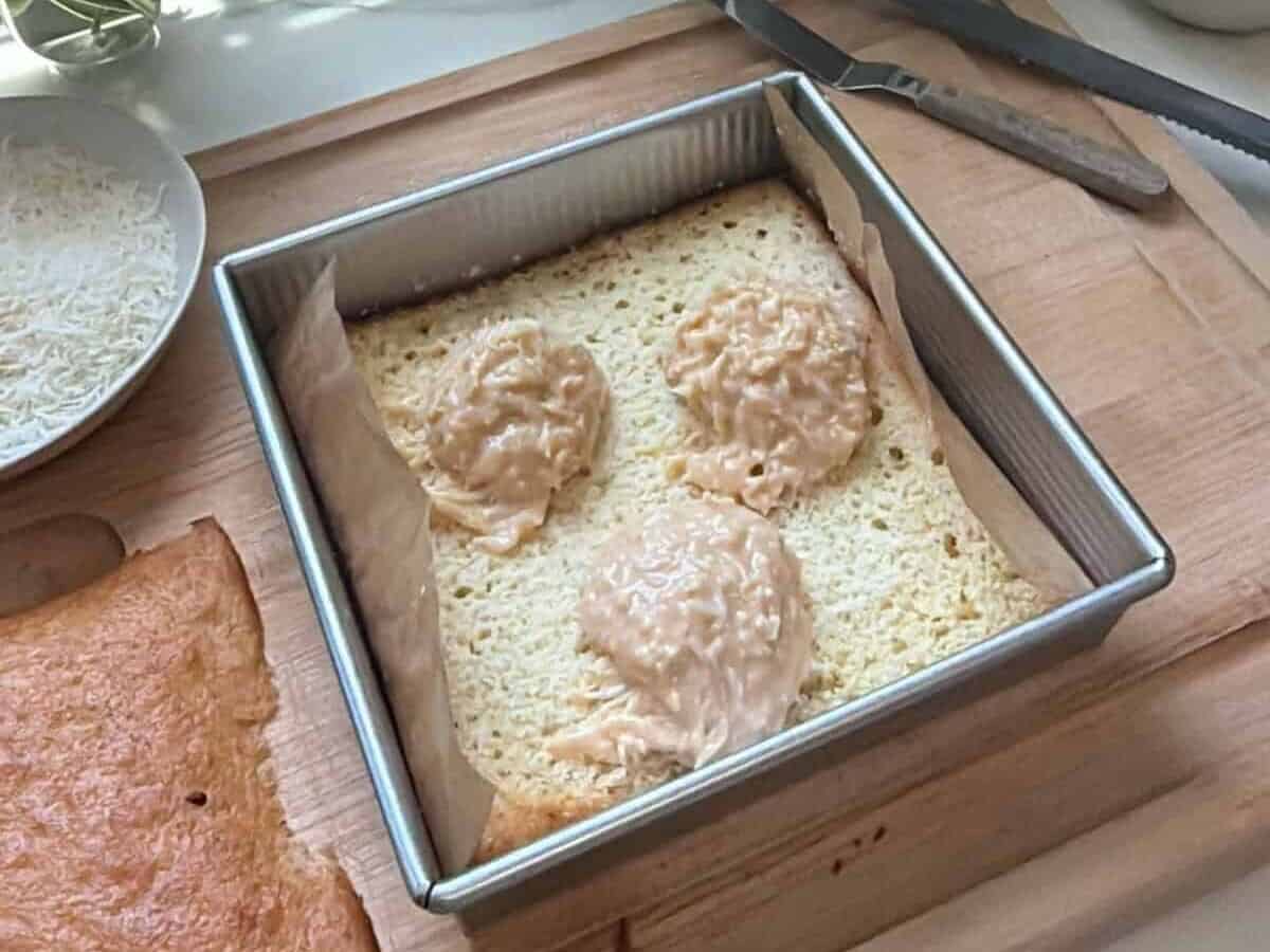 Scoops of coconut filling on the base of the cake.
