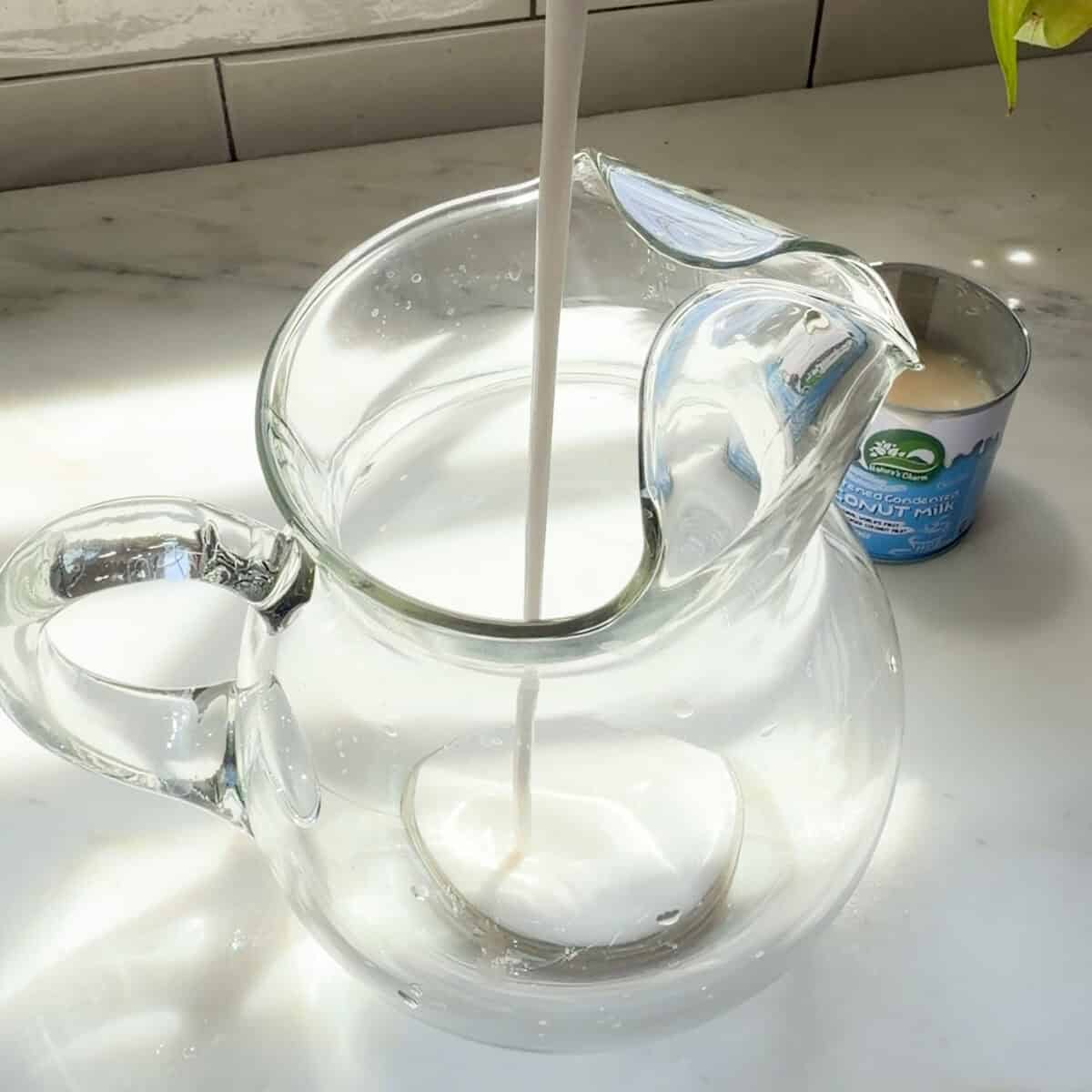Pouring coconut milk into large pitcher.