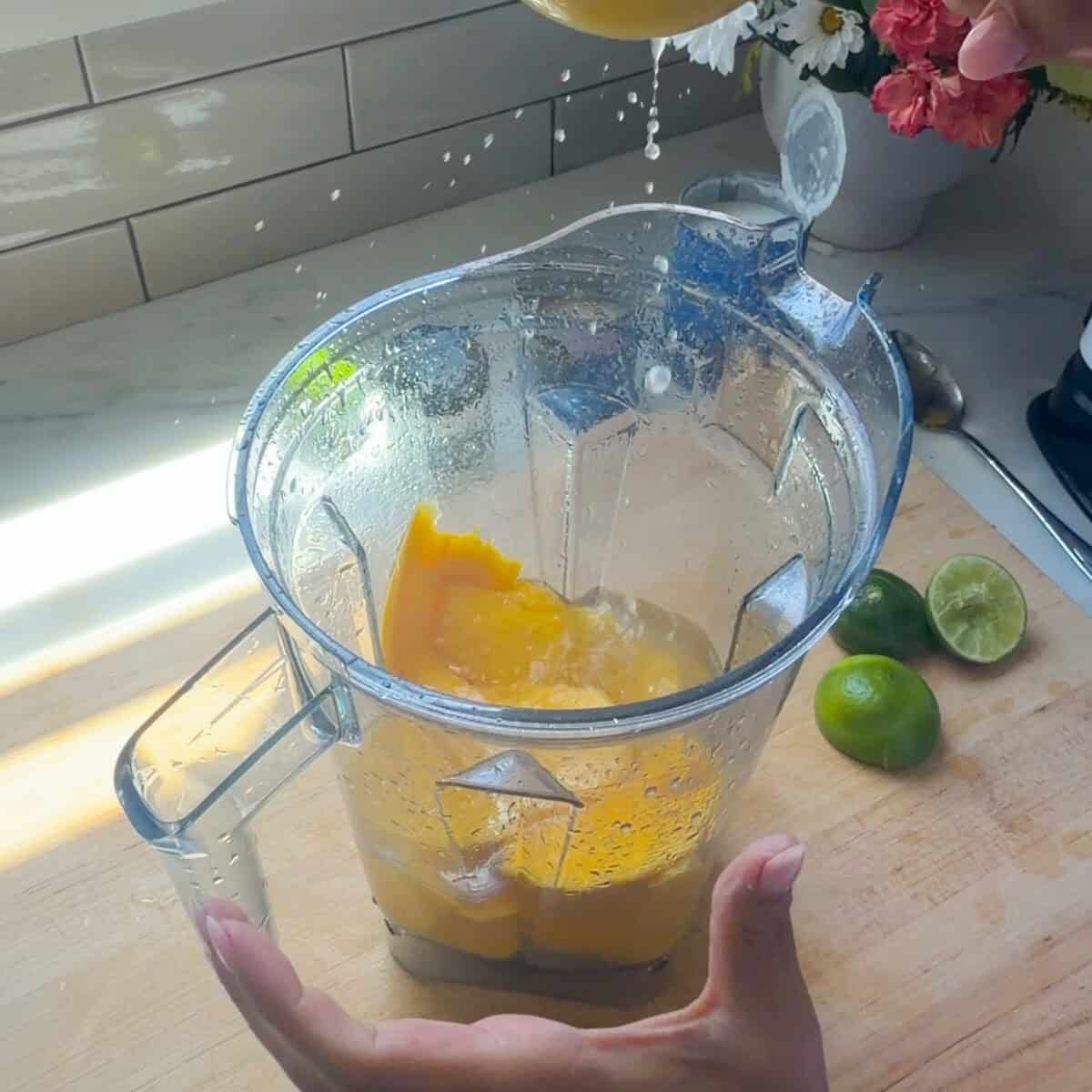 Mangoes, water, and lime juice in blender.