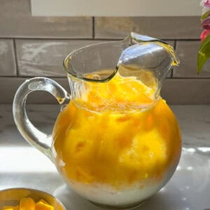 Creamy mango agua fresca in pitcher.