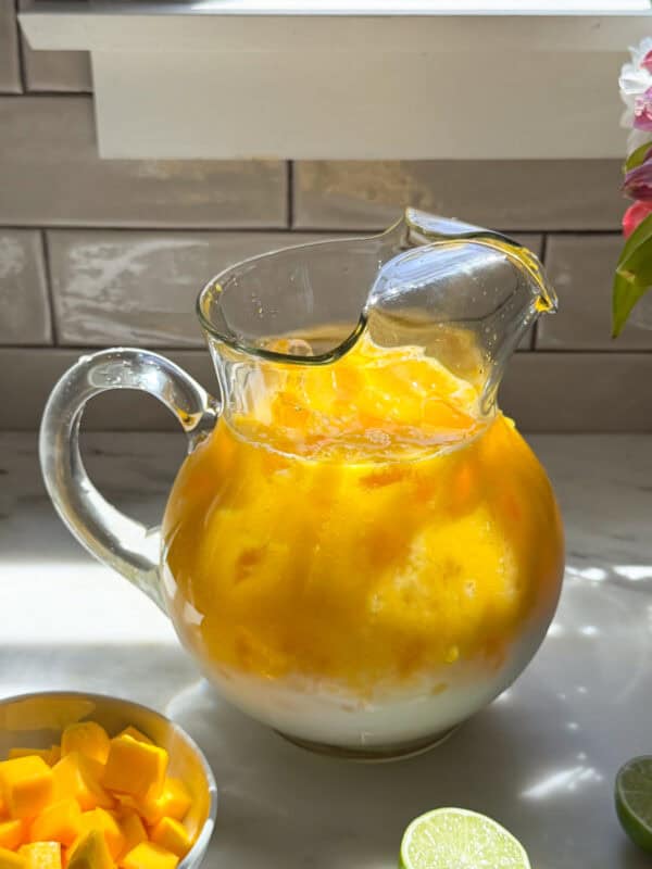 Creamy mango agua fresca in pitcher.