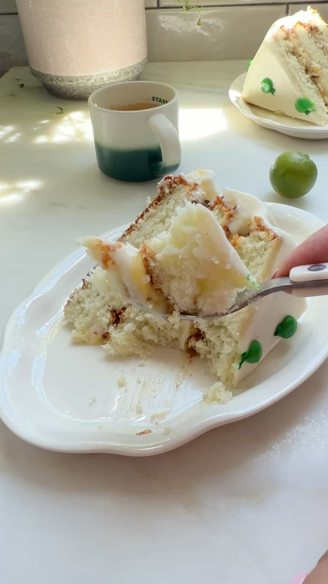 Forkful of key lime cake and a slice on a plate.
