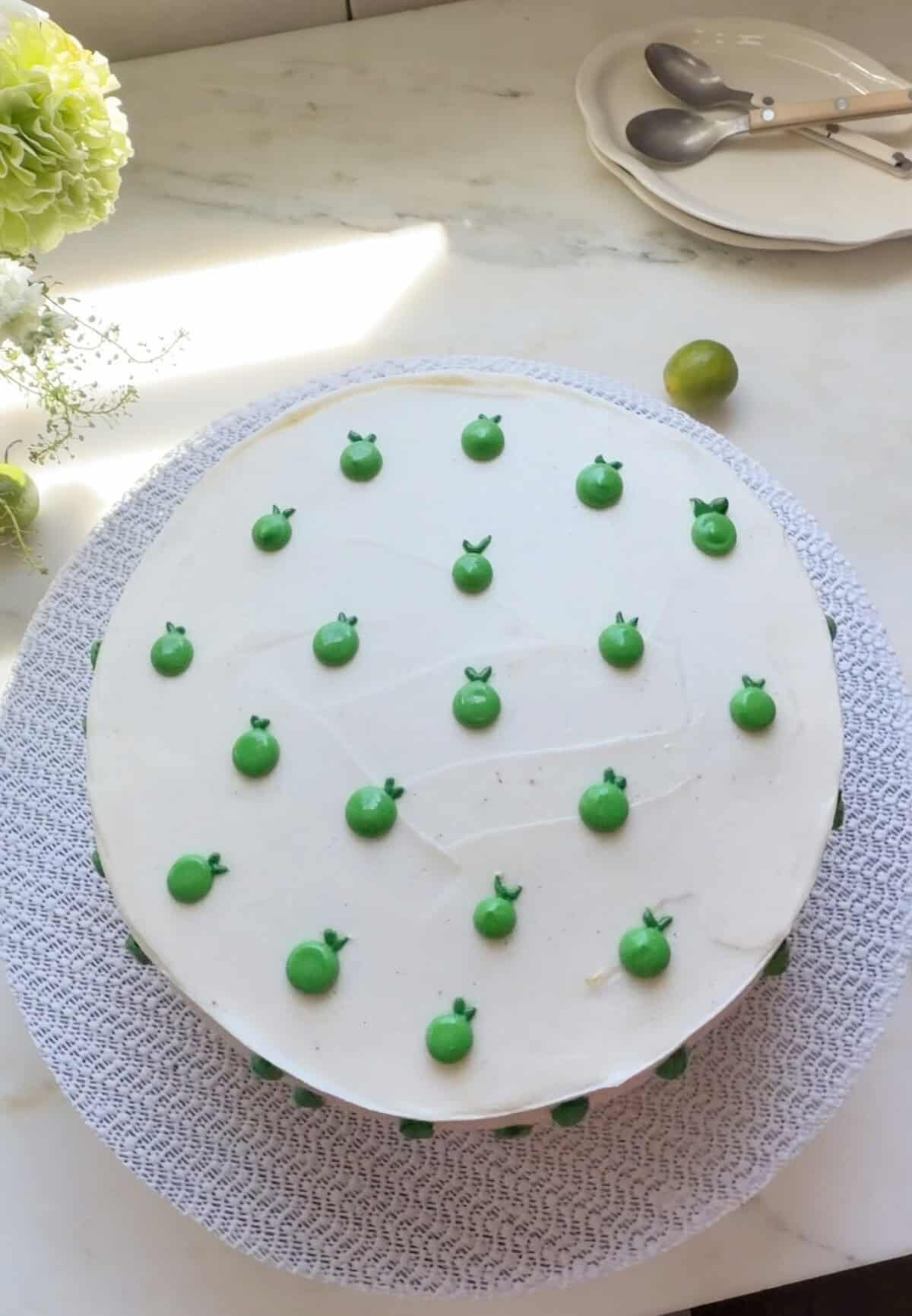 Whole key lime cake frosted and decorated with key limes.
