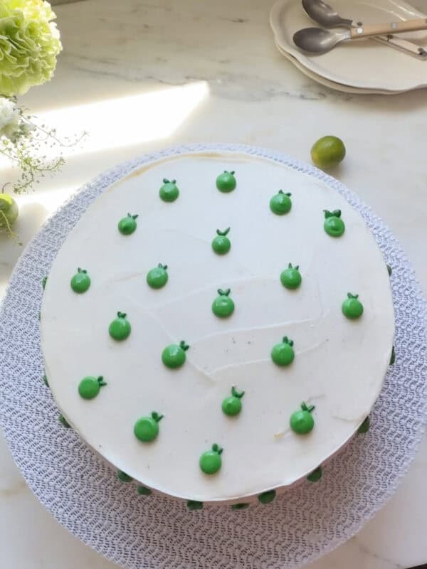 Whole key lime cake frosted and decorated with key limes.