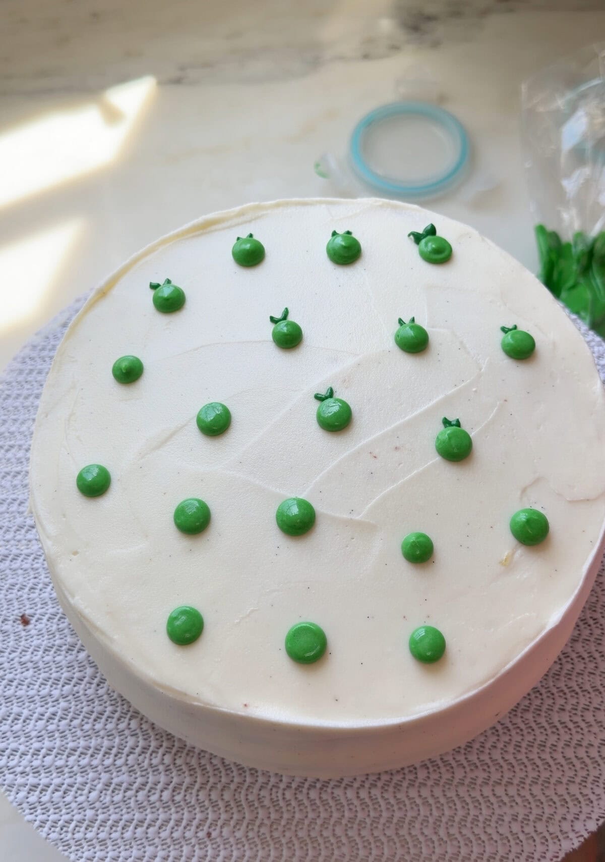 Frosted key lime cake partially decorated with key limes.