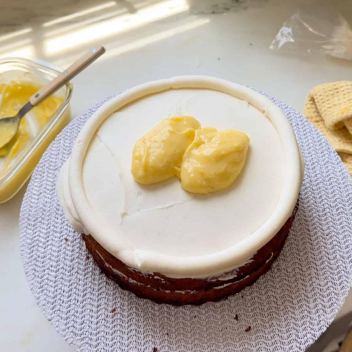 Dollops of key lime curd on frosted cake layer.
