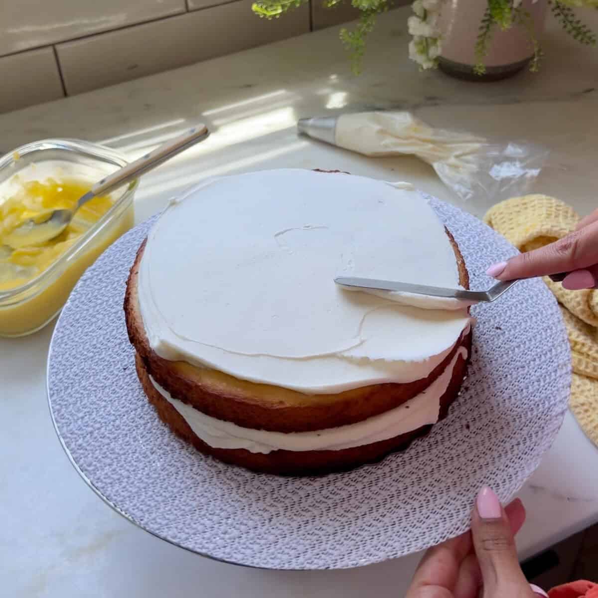 Frosting cake layer with mini offset spatula.