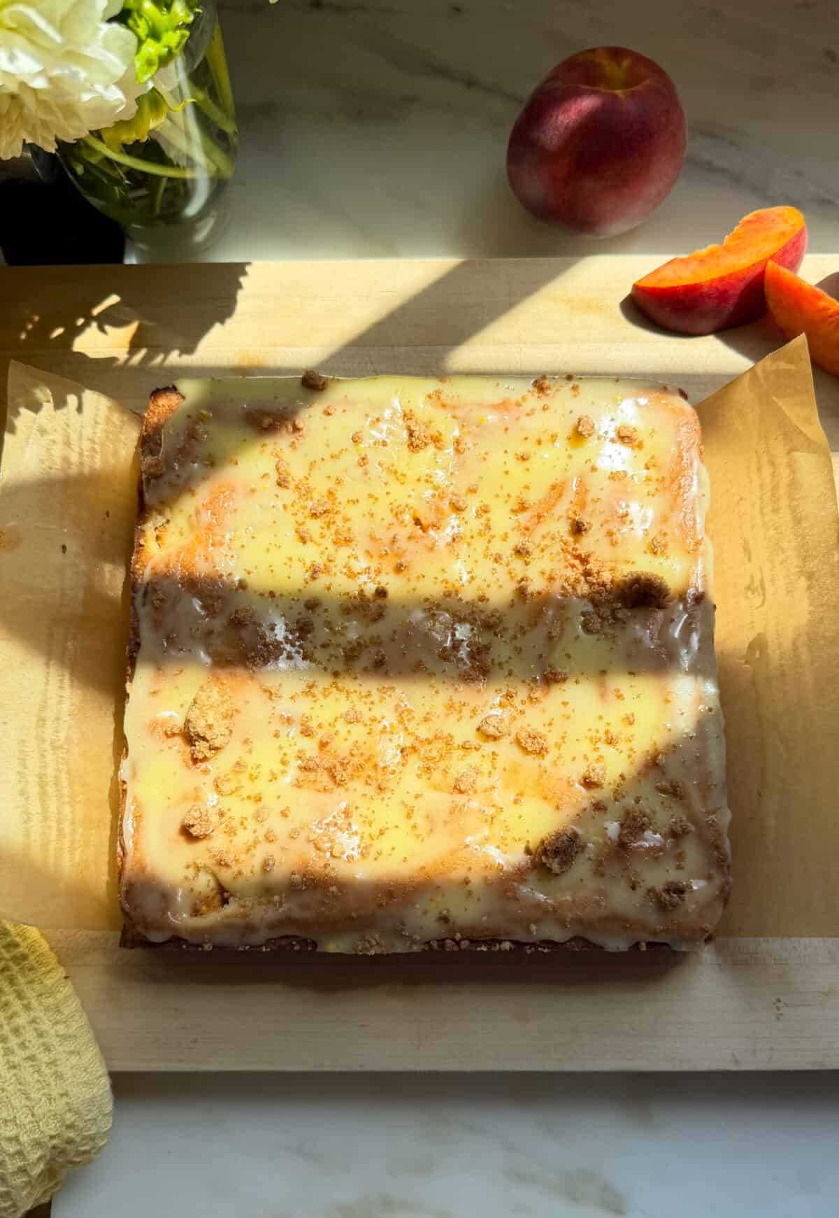 Glazed and set peach cobbler brownies on cutting board.