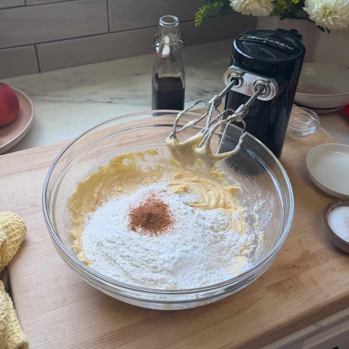 Adding dry ingredients and cinnamon to Peach Cobbler Brownie batter.