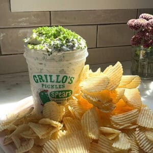 Pickle dip with mound of ruffle chips on a platter.