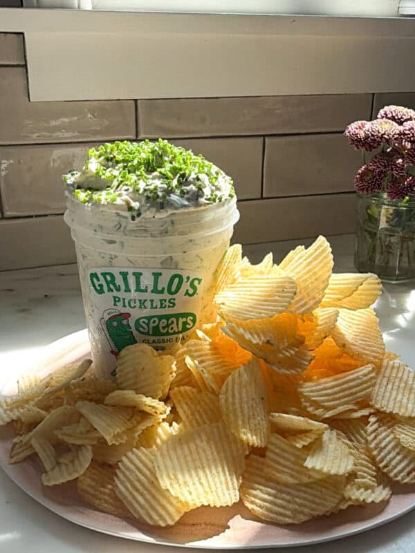 Pickle dip with mound of ruffle chips on a platter.