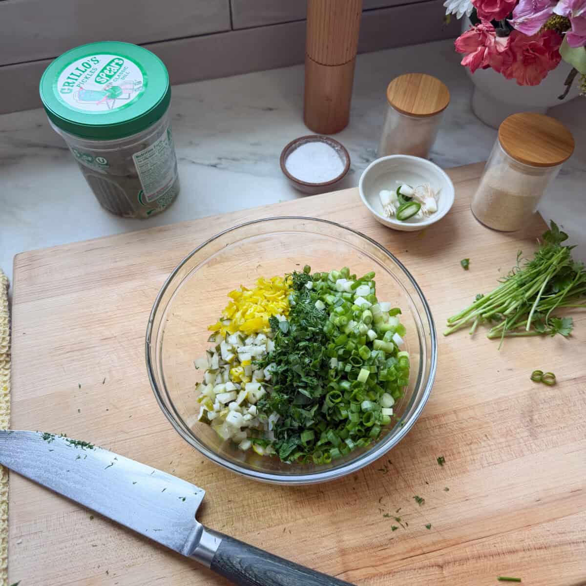 Chopped veggies, herbs, and onions in a bowl.