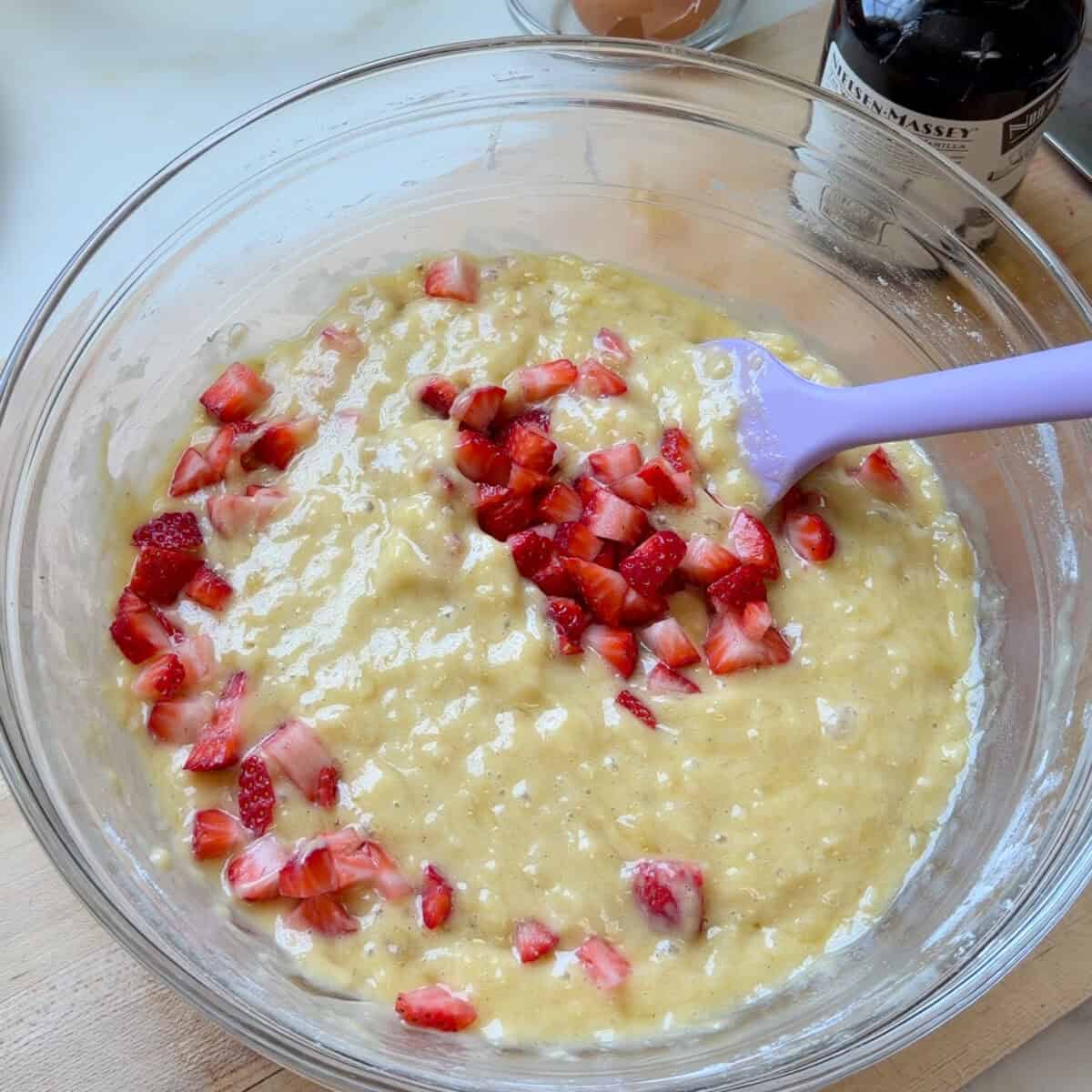 Folding fresh strawberries into the batter.
