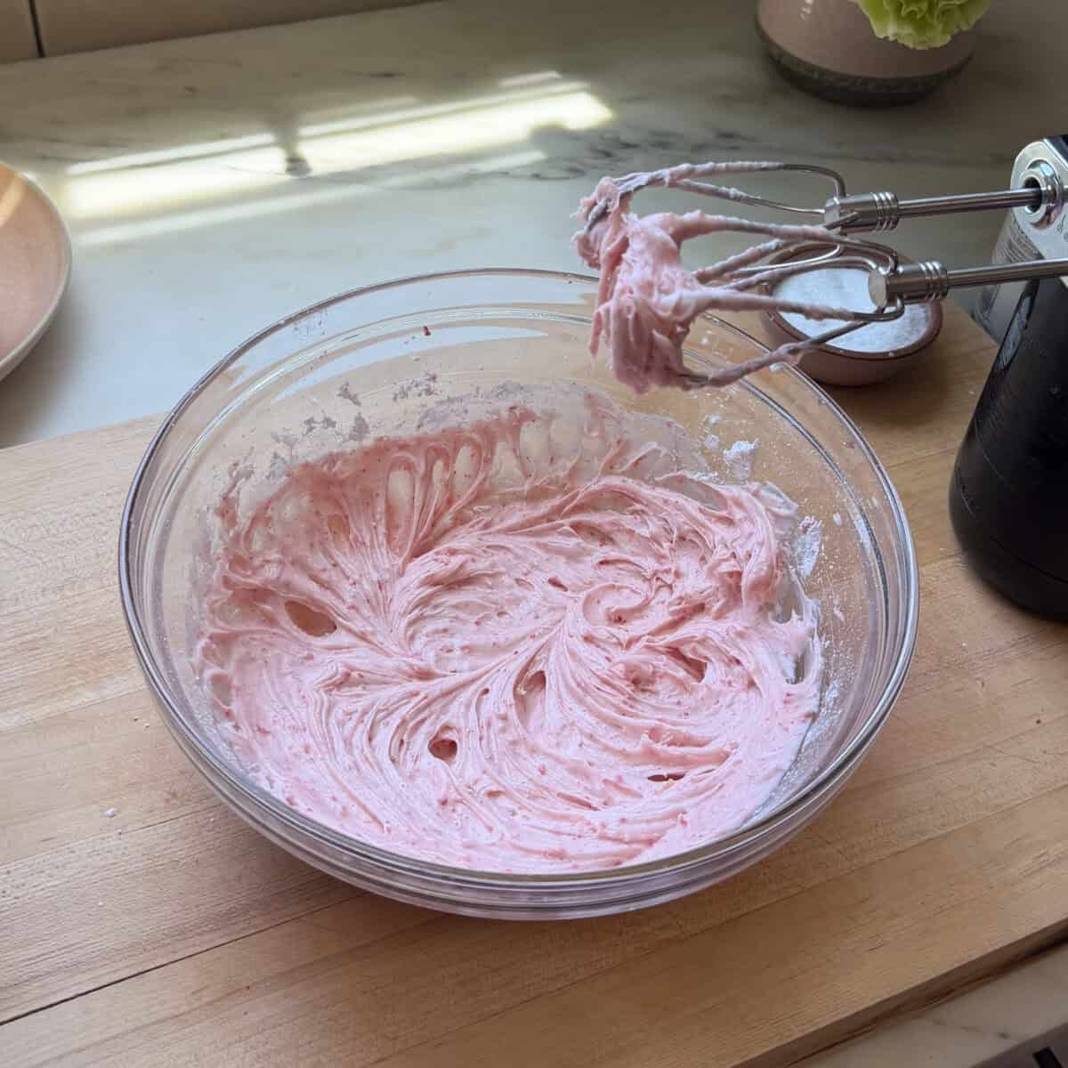 Strawberry cream cheese frosting in a medium bowl.