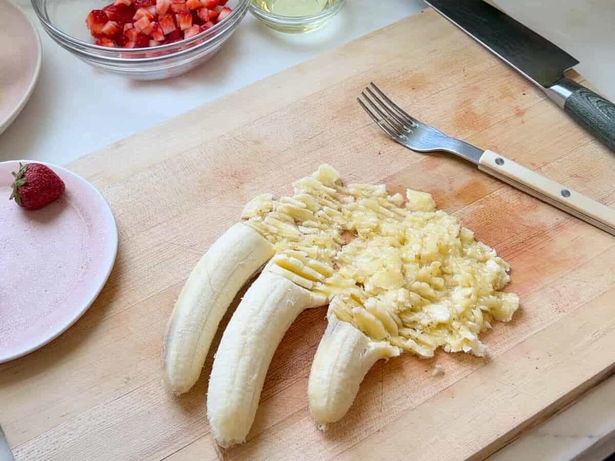 Mashed banana on cutting board.