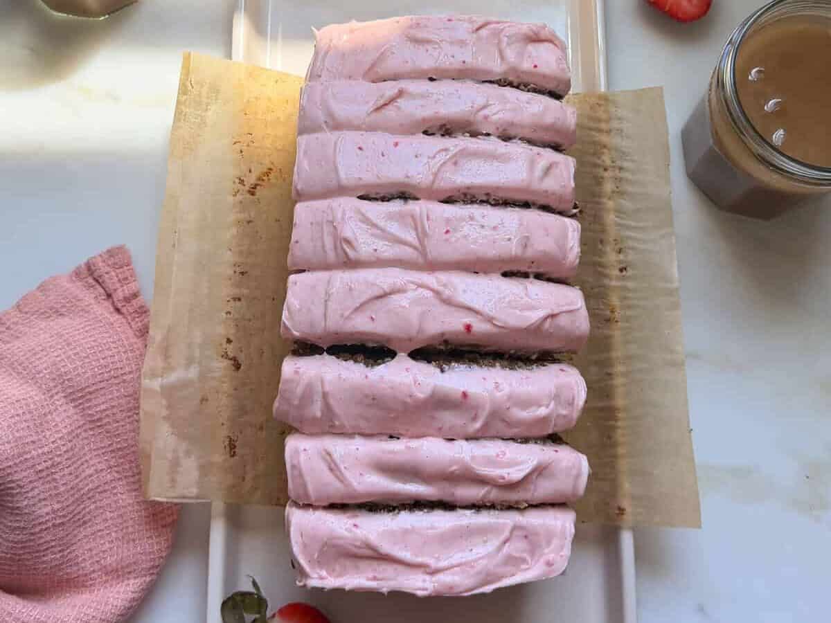 Frosted and sliced strawberry banana bread.