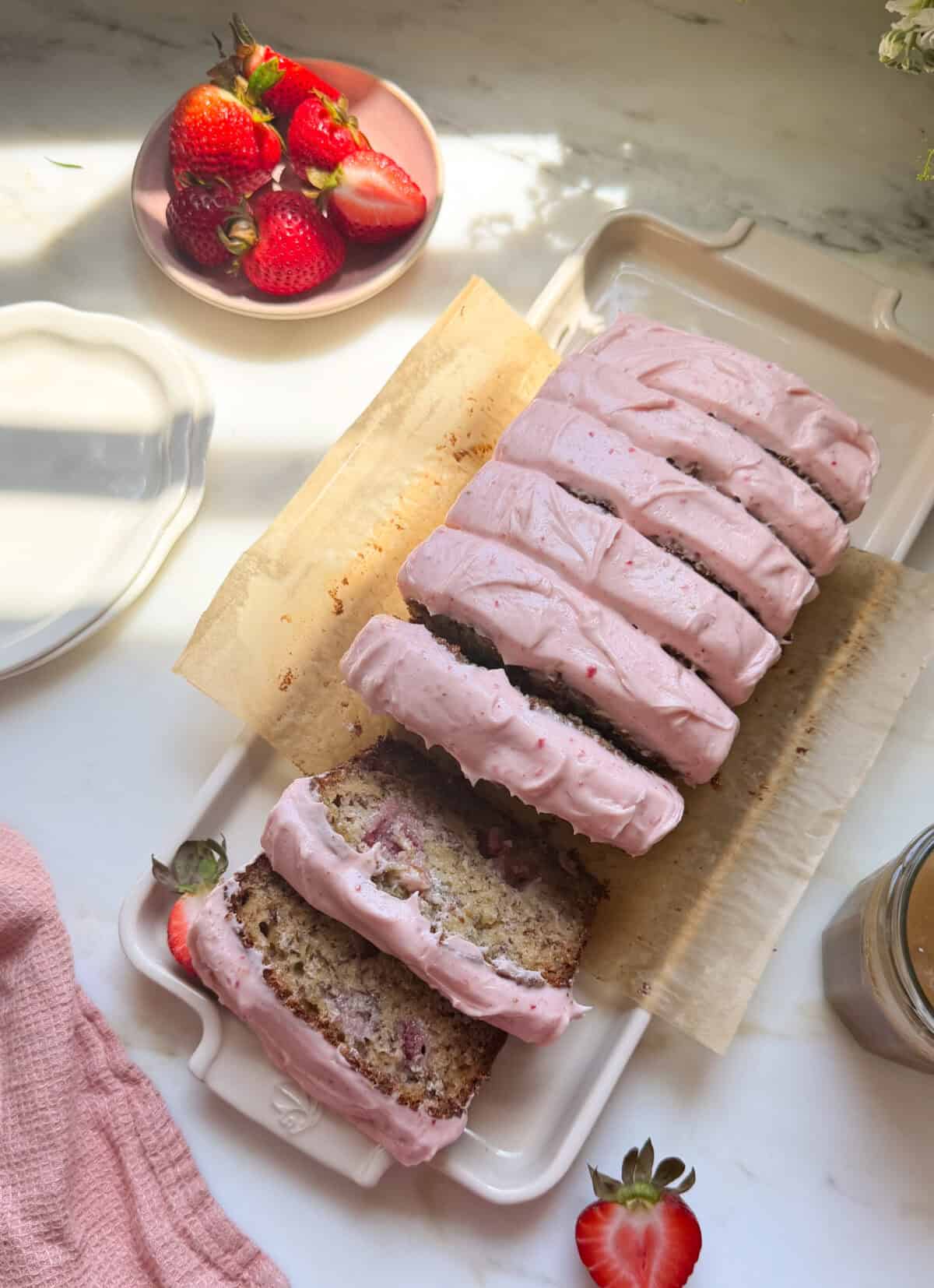 Frosted and sliced strawberry banana bread.