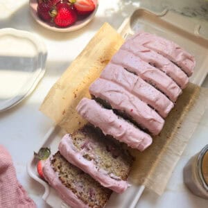 Frosted and sliced strawberry banana bread.