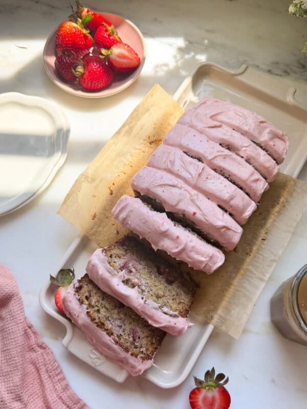 Frosted and sliced strawberry banana bread.