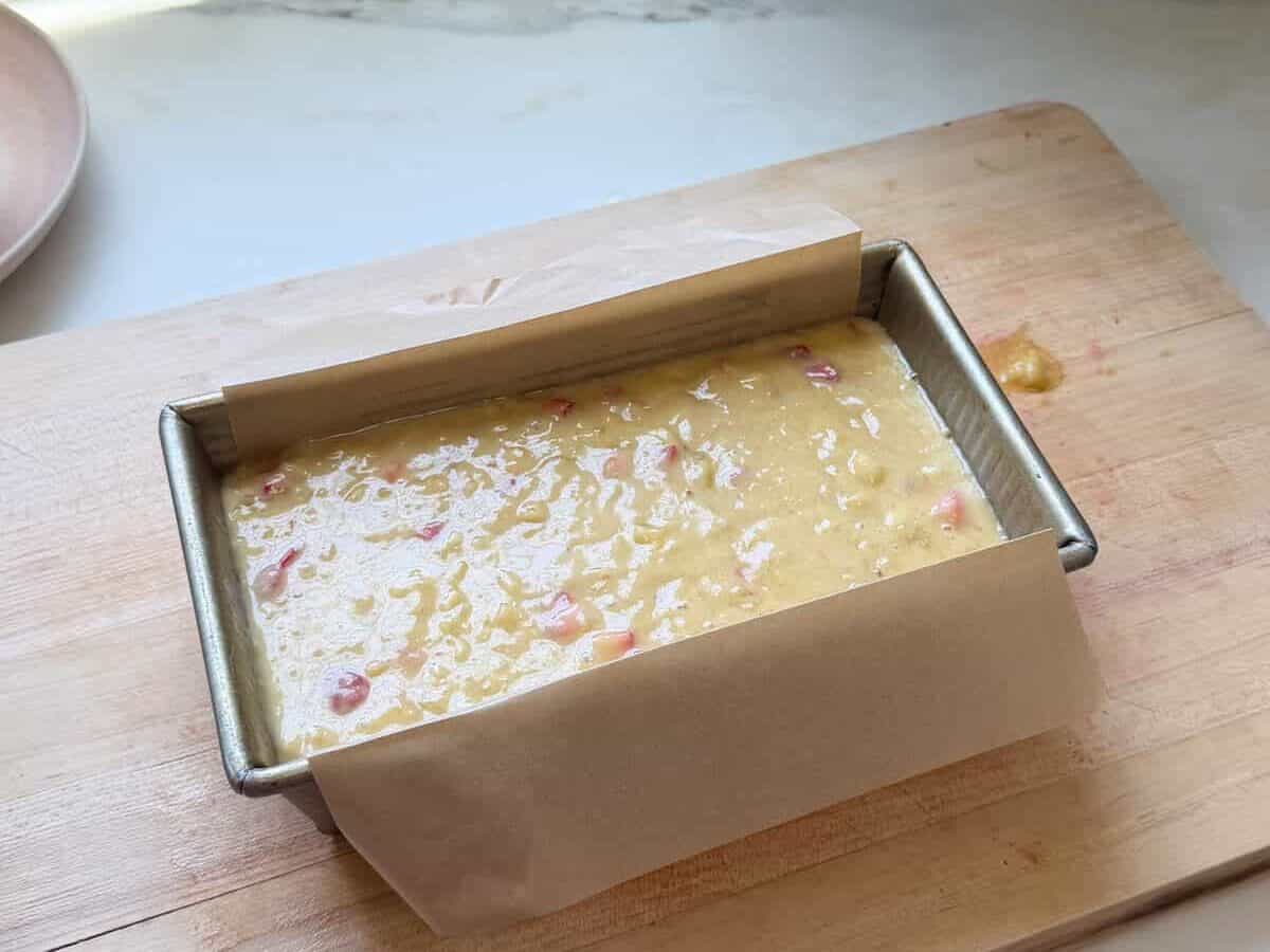 Strawberry Banana Bread batter in a prepared loaf pan.