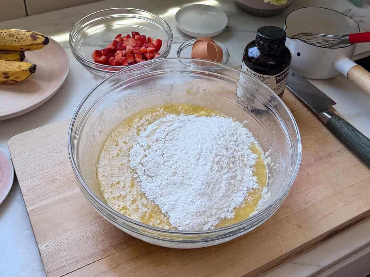 Flour on top of the wet batter in a bowl.