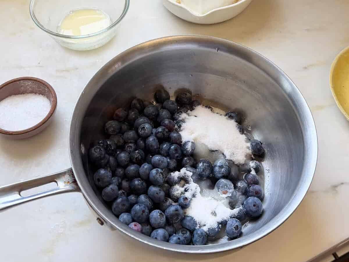 Blueberries, sugar, and lemon juice in a pot.