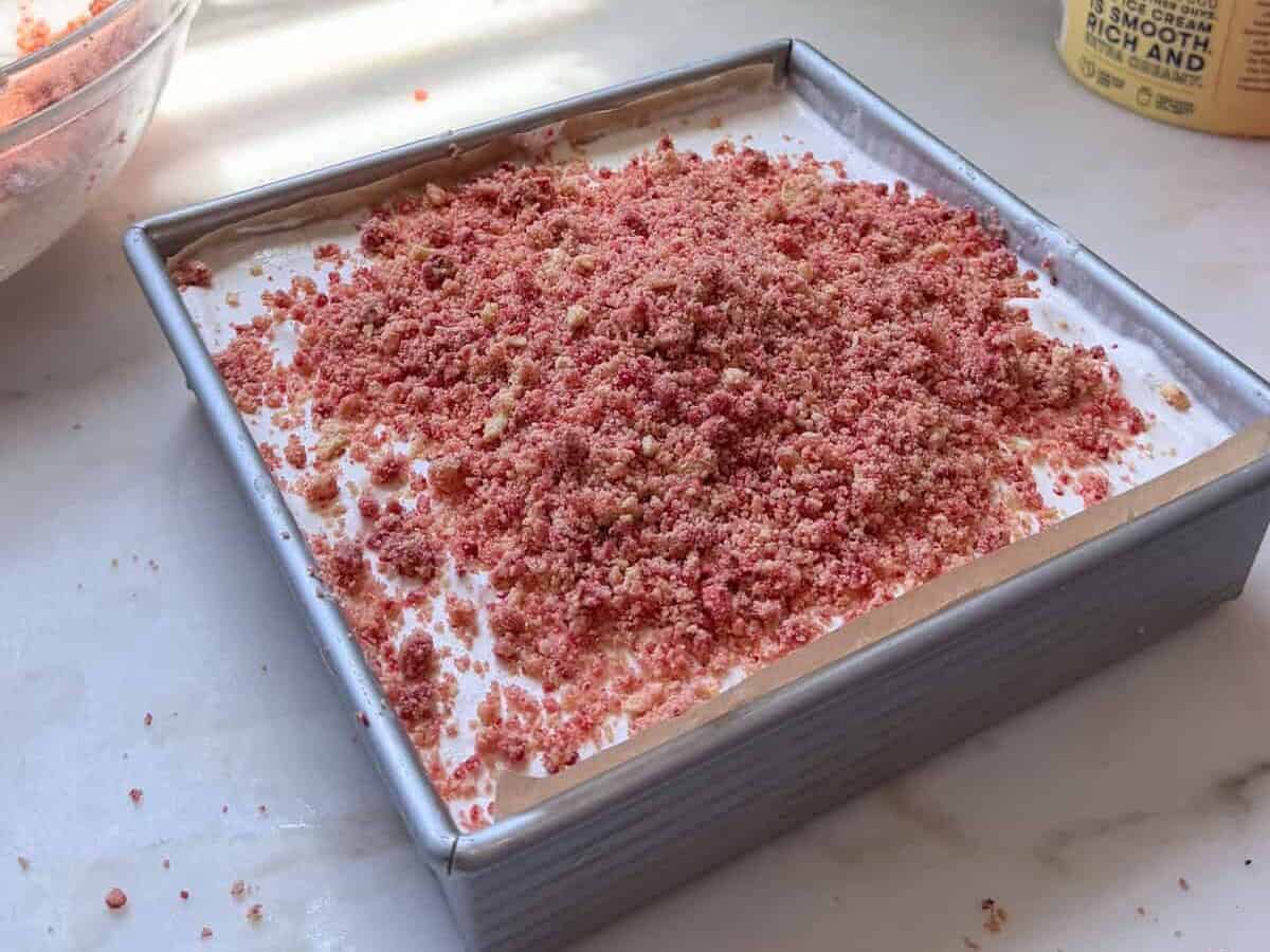 Top layer of crushed golden Oreos and strawberry mixture over the ice cream.