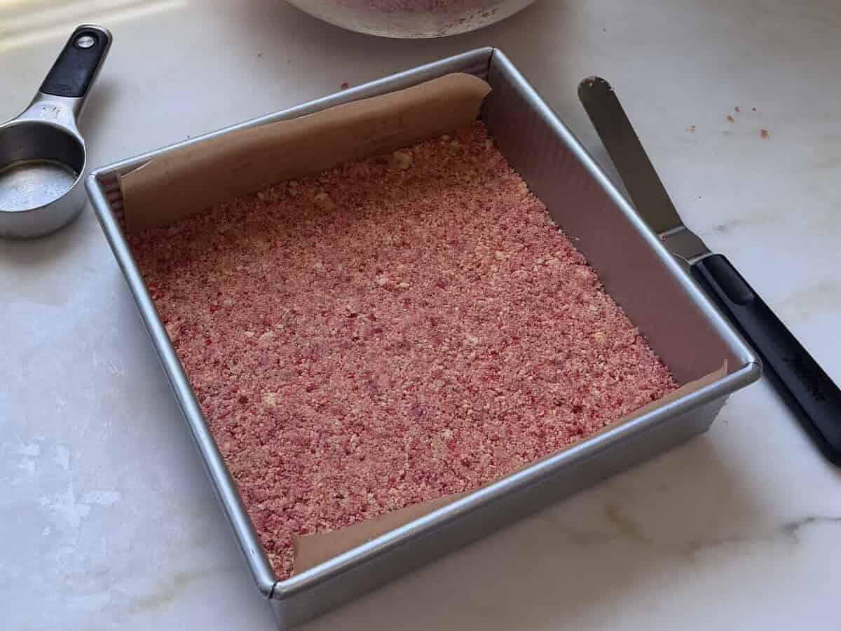 A smooth layer of the strawberry and golden oreos mixture in 8x8inch baking pan.